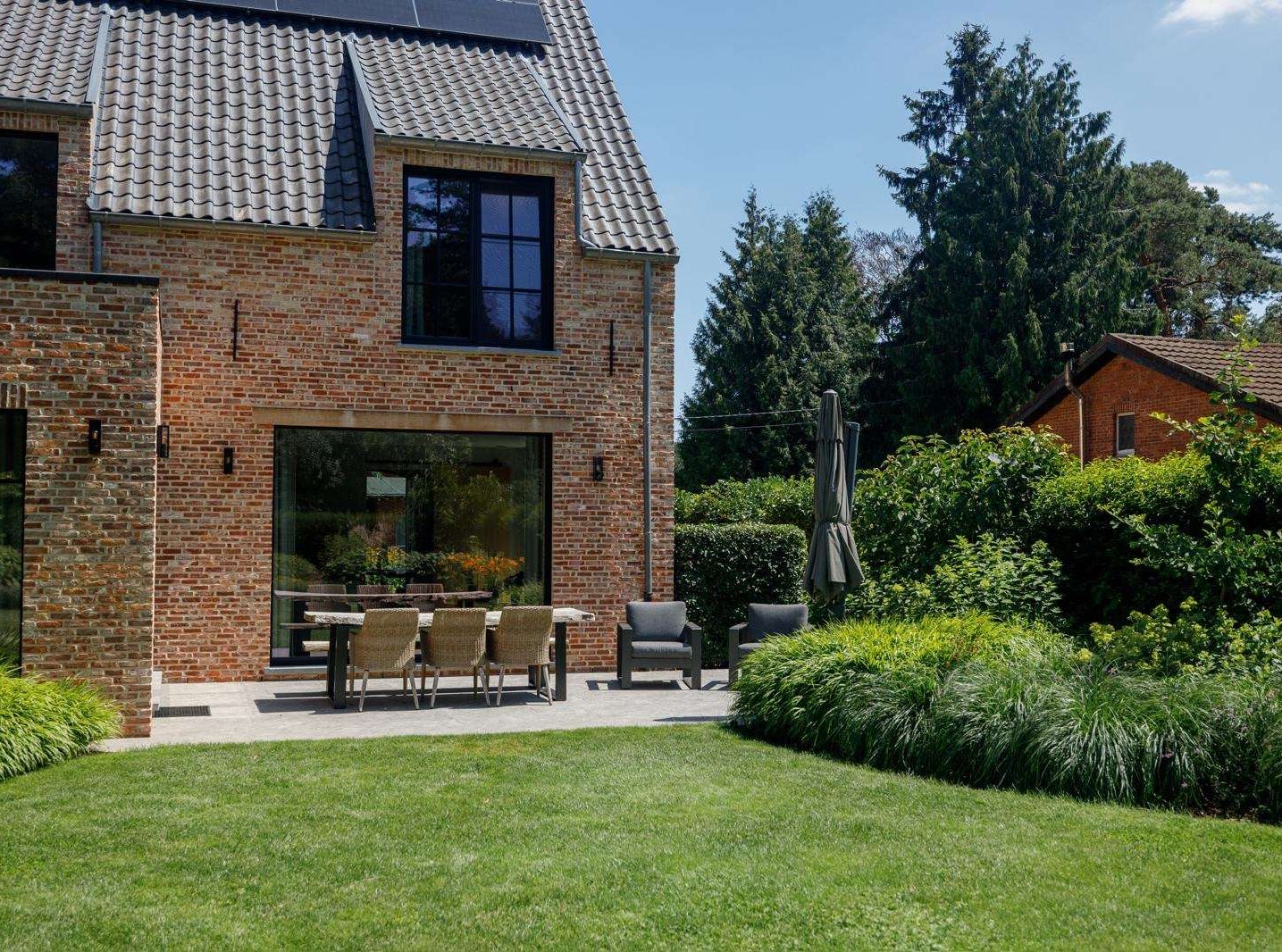 Groen gazon bij een aangelegde tuin